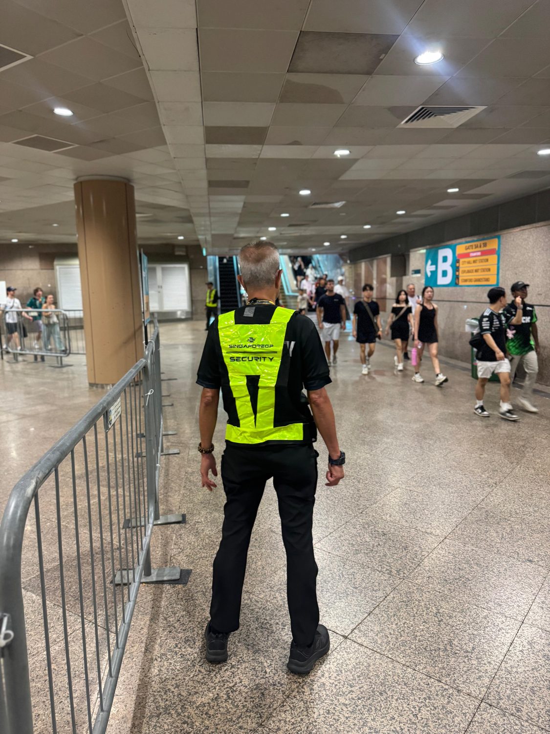 A Hawkeye officer directing a crowd at a Singapore stadium