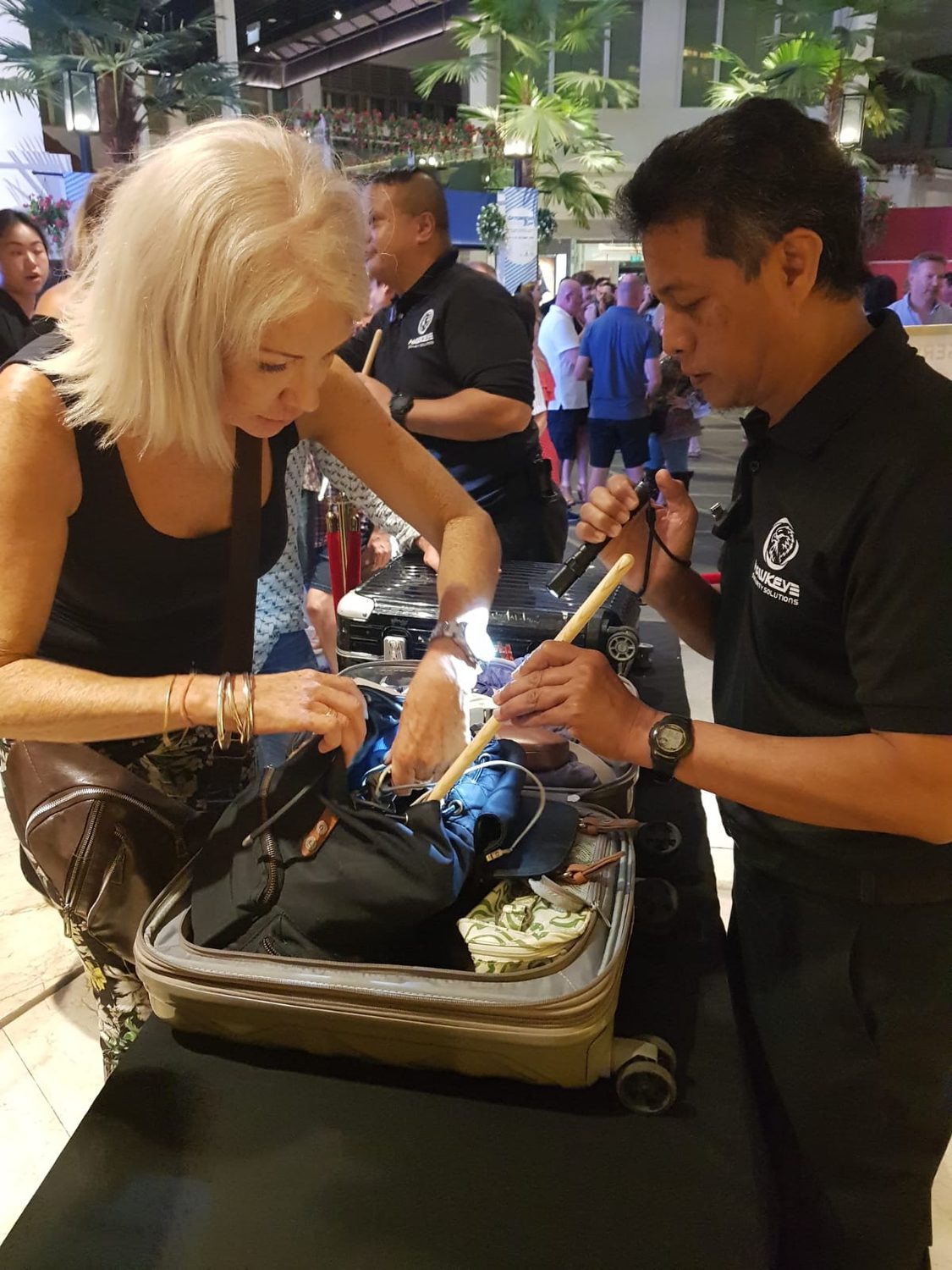 A Hawkeye officer screening a guest's bag at a Singapore event